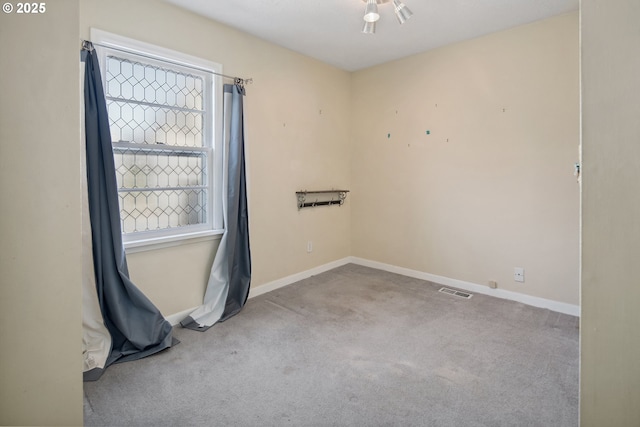 unfurnished room with carpet flooring and baseboards