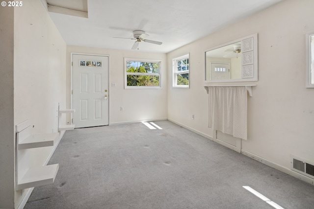 carpeted entrance foyer with ceiling fan and baseboards