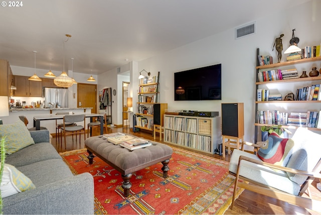living area featuring visible vents and wood finished floors
