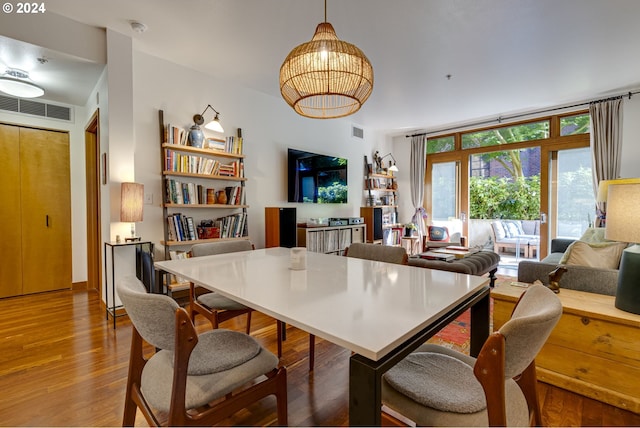 dining area with visible vents and wood finished floors