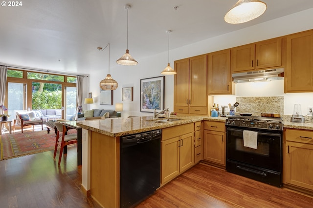 kitchen featuring a peninsula, open floor plan, under cabinet range hood, dark wood-style floors, and black appliances
