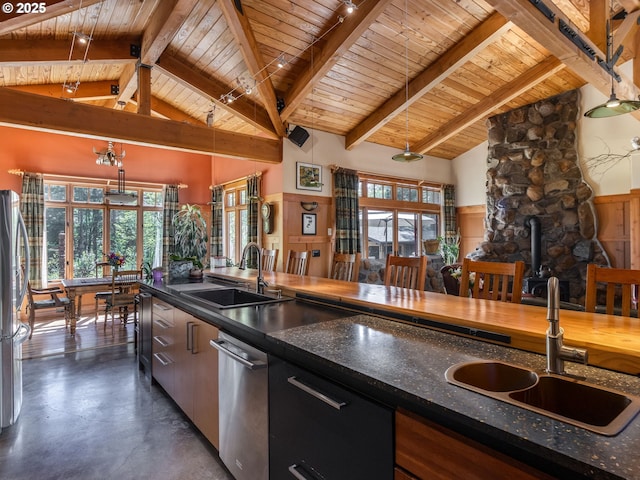 kitchen with beam ceiling, a sink, a healthy amount of sunlight, and wood ceiling