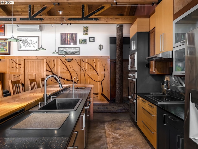 kitchen featuring dark countertops, concrete flooring, a sink, under cabinet range hood, and stainless steel appliances