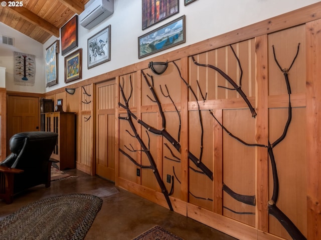 interior space with beam ceiling, a wall mounted air conditioner, finished concrete floors, visible vents, and wood ceiling