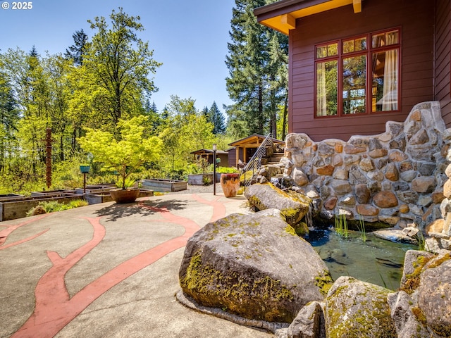 exterior space with a patio and a garden pond