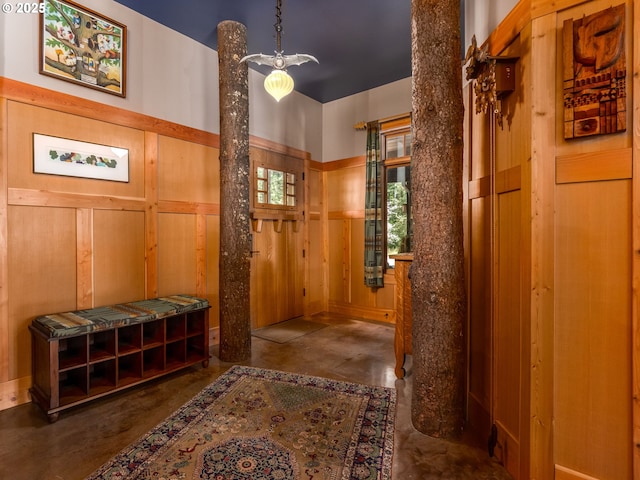corridor with wood walls and concrete floors