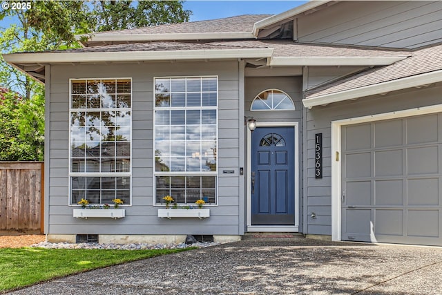 property entrance featuring fence and a shingled roof