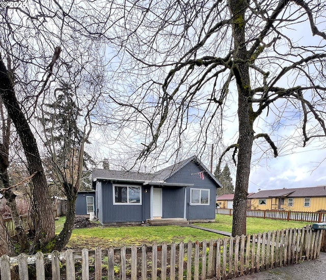 view of front facade with a fenced front yard and a front lawn