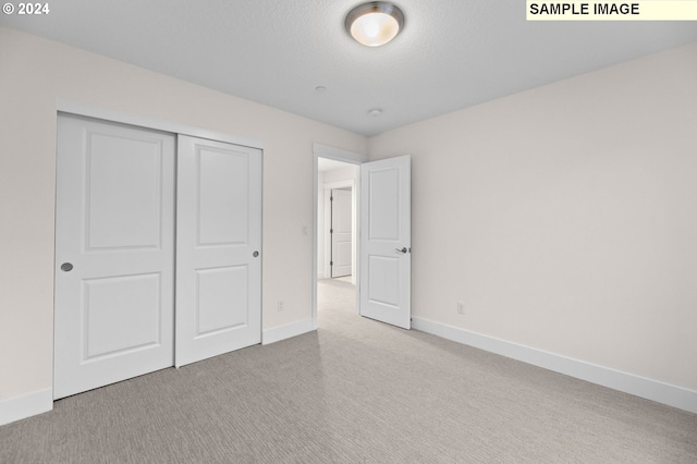 4206 NE 188th St Lot 328, Vancouver, WA 98686 - unfurnished bedroom featuring a closet, a textured ceiling, baseboards, and carpet floors