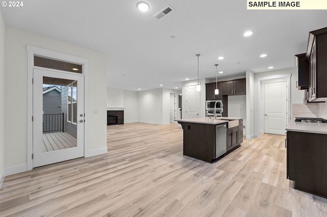 4206 NE 188th St Lot 328, Vancouver, WA 98686 - kitchen featuring stainless steel appliances, a fireplace, open floor plan, light countertops, and light wood-style floors