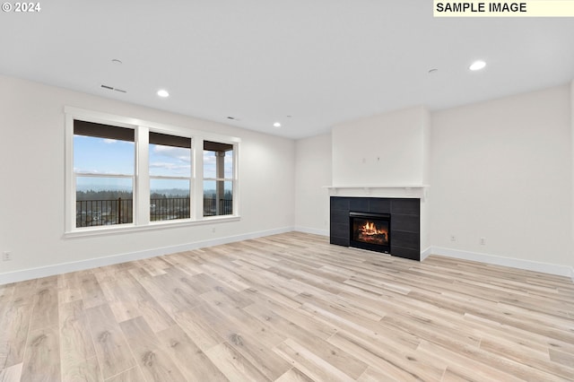 4206 NE 188th St Lot 328, Vancouver, WA 98686 - unfurnished living room with baseboards, a tile fireplace, light wood-style flooring, and visible vents