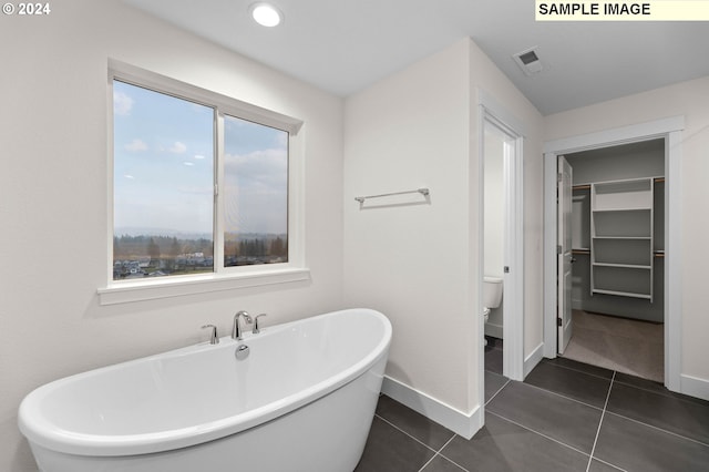 4206 NE 188th St Lot 328, Vancouver, WA 98686 - bathroom with toilet, a walk in closet, tile patterned floors, a freestanding bath, and baseboards