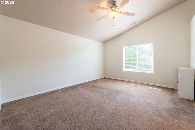 spare room featuring visible vents, carpet, a ceiling fan, baseboards, and vaulted ceiling