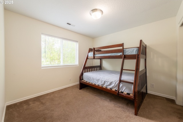 carpeted bedroom with visible vents and baseboards