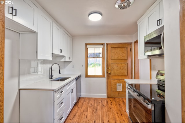 3406 E 12th St, Vancouver, WA 98660 - kitchen with appliances with stainless steel finishes, light wood finished floors, light countertops, white cabinetry, and tasteful backsplash