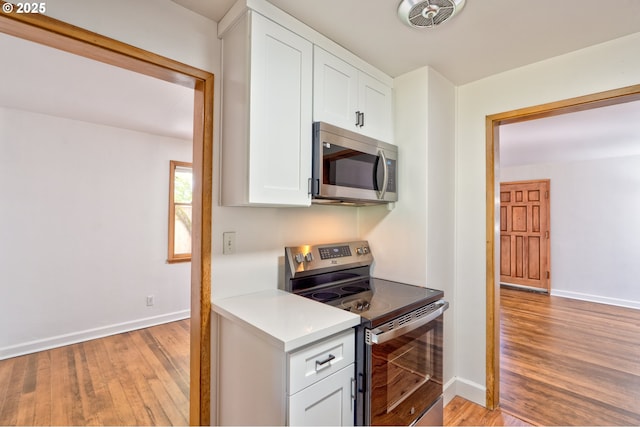 3406 E 12th St, Vancouver, WA 98660 - kitchen featuring stainless steel appliances, light wood-type flooring, white cabinets, and light countertops
