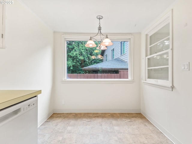 unfurnished dining area with an inviting chandelier, baseboards, and a wealth of natural light