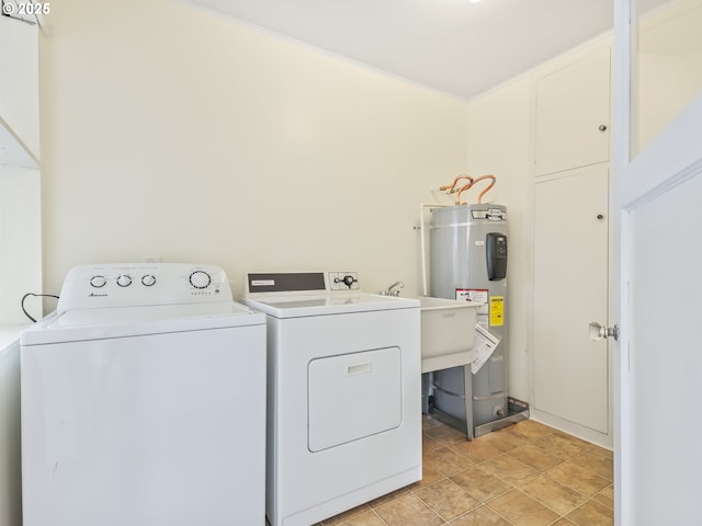 washroom featuring water heater, washing machine and clothes dryer, and laundry area