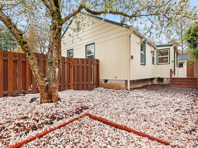 view of home's exterior with crawl space and fence