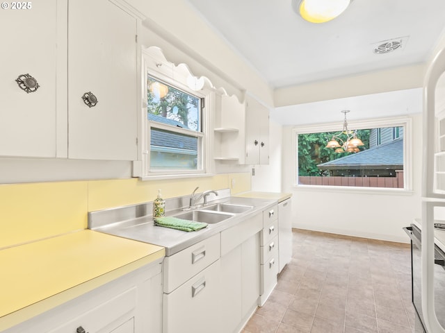 kitchen featuring a wealth of natural light, white dishwasher, visible vents, and light countertops