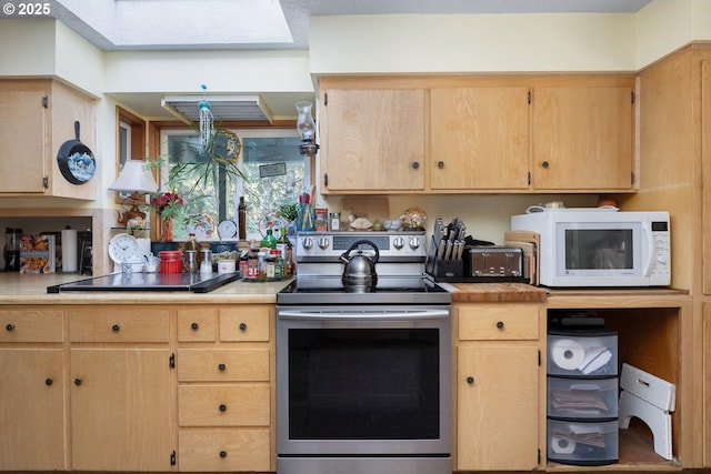 kitchen with stainless steel electric stove and light brown cabinetry