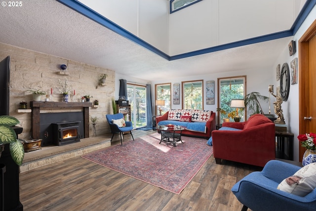 living room featuring a healthy amount of sunlight, dark hardwood / wood-style flooring, a textured ceiling, and a high ceiling