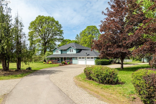 traditional home featuring asphalt driveway, covered porch, a front lawn, and a garage