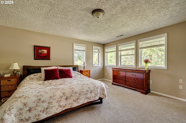 carpeted bedroom with baseboards and a textured ceiling