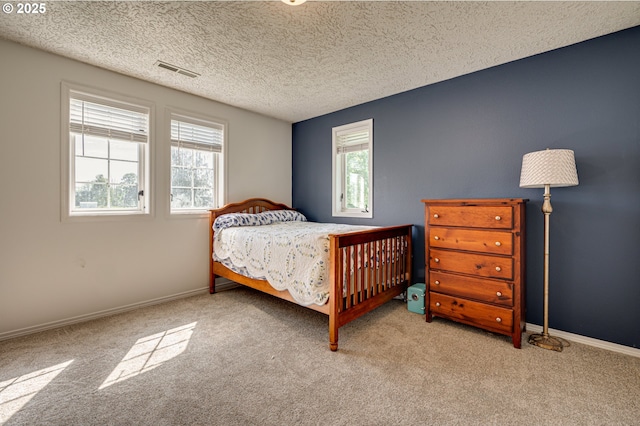 carpeted bedroom featuring baseboards and a textured ceiling