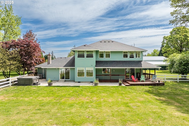 back of house featuring a hot tub, a patio area, a shingled roof, and a chimney