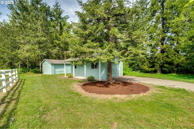 view of yard with an outbuilding, driveway, and a garage
