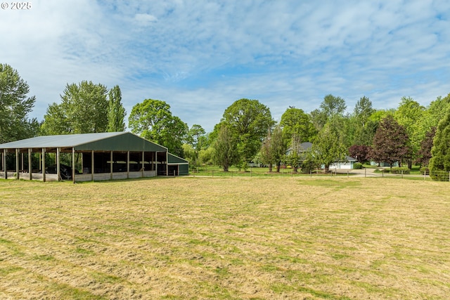 surrounding community featuring an outdoor structure and view of wooded area