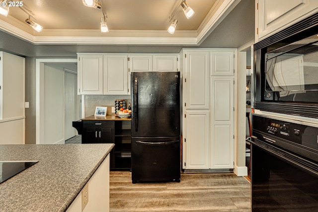 kitchen with black appliances, rail lighting, ornamental molding, light wood-style flooring, and white cabinets