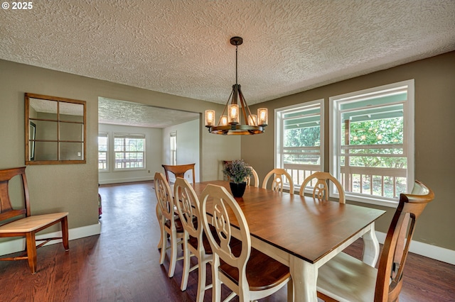 dining space featuring baseboards, a textured ceiling, a chandelier, and dark wood finished floors