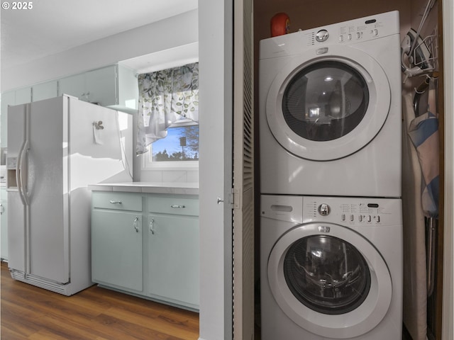 laundry room featuring dark wood-type flooring and stacked washer and clothes dryer