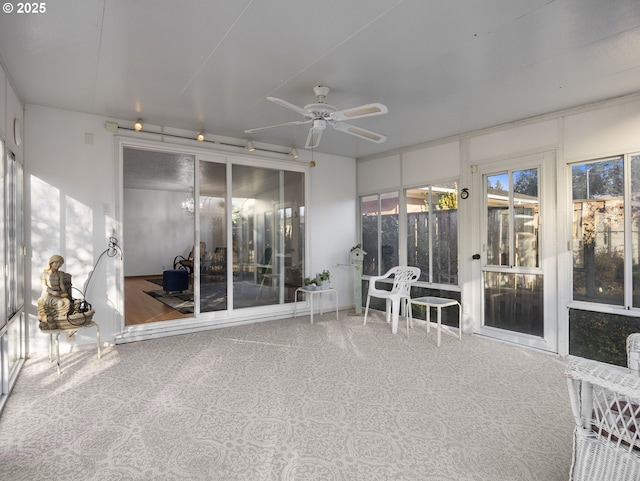 unfurnished sunroom with ceiling fan