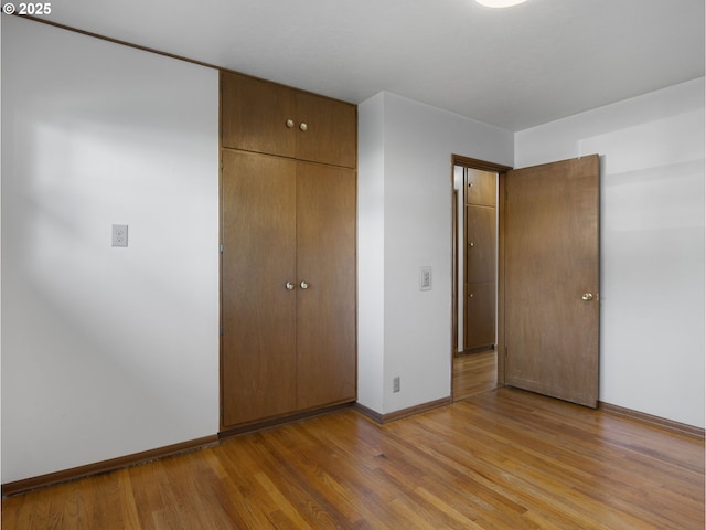 unfurnished bedroom with a closet and light wood-type flooring