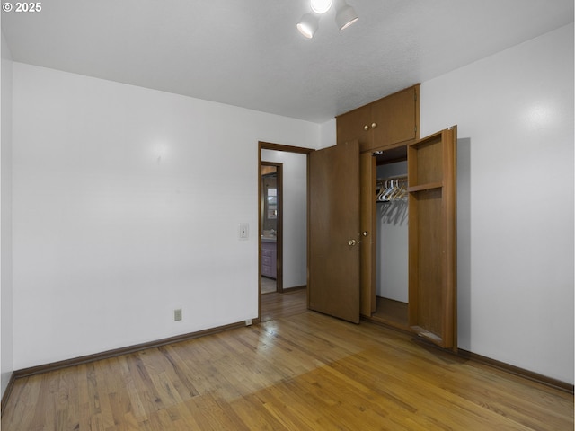 unfurnished bedroom with a closet and light hardwood / wood-style flooring