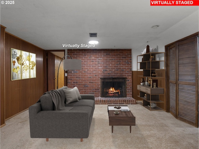 living room featuring light carpet, wooden walls, and a brick fireplace