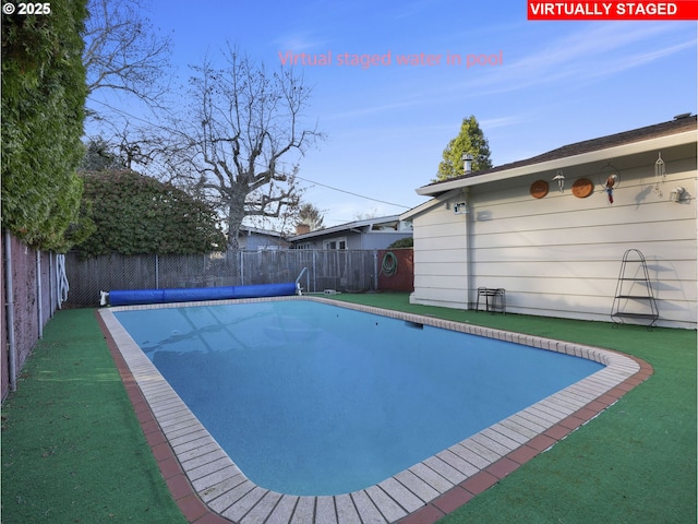 view of pool featuring a lawn