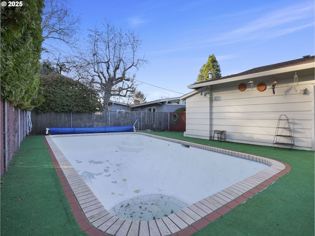 view of swimming pool with a yard