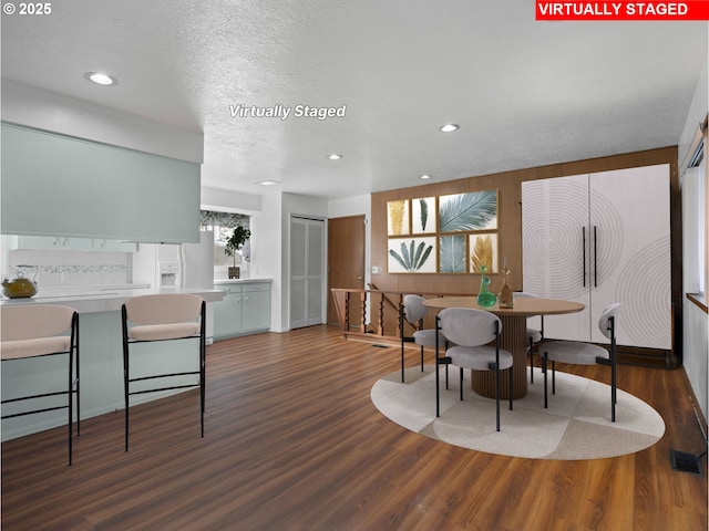 dining area featuring dark wood-type flooring and a textured ceiling