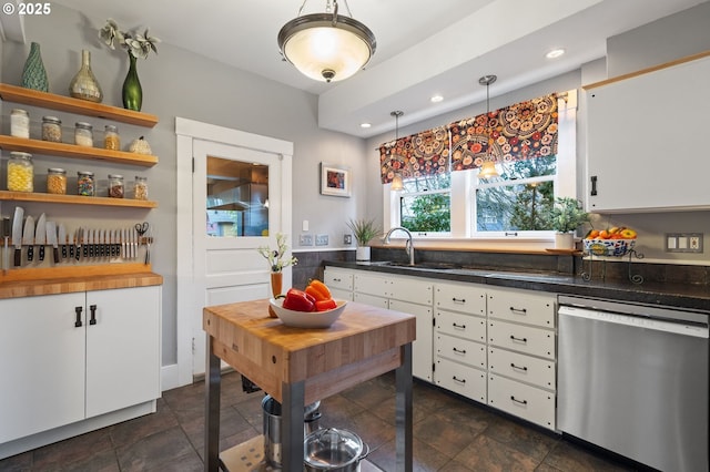 kitchen with white cabinetry, hanging light fixtures, stainless steel dishwasher, open shelves, and dark countertops