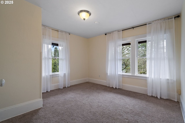 carpeted empty room featuring plenty of natural light and baseboards