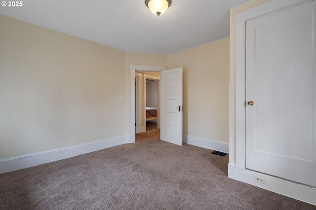 unfurnished bedroom featuring carpet flooring, visible vents, and baseboards