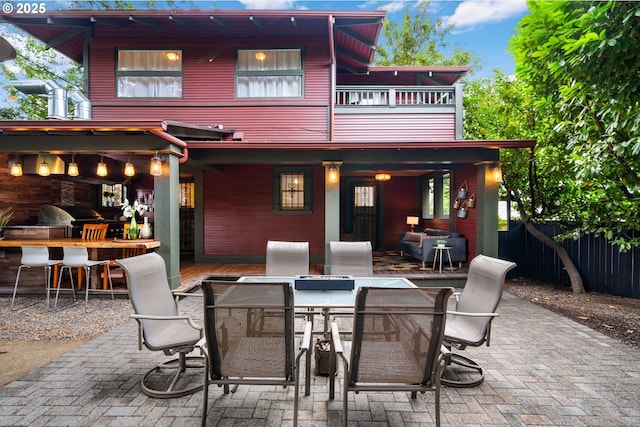 view of patio featuring an outdoor bar, fence, a balcony, and grilling area