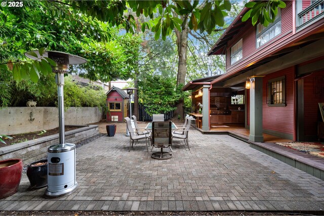 view of patio / terrace featuring a storage shed, a fenced backyard, outdoor dining area, and an outdoor structure