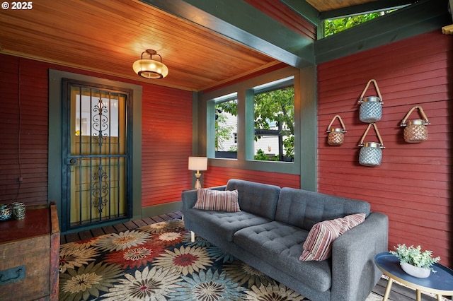 exterior space with wooden ceiling, ornamental molding, and wood walls