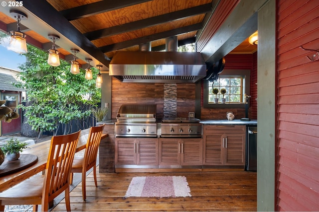 kitchen featuring decorative light fixtures, light countertops, brown cabinetry, wood finished floors, and exhaust hood