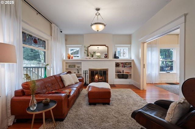 living area featuring a brick fireplace and light wood-style flooring